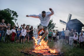 Участник празднования Ивана Купала прыгает через костер в селе Витачев под Киевом