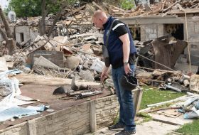An investigator collects the debris after guided aerial bombs hit Kharkiv