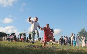 Участники празднования Ивана Купала прыгают через костер