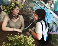 Young woman under an umbrella sitting at a wooden table