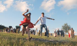 Участники празднования Ивана Купала прыгают через костер