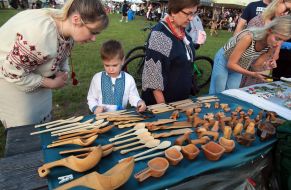 Buyers look at woodcarving products on the counter