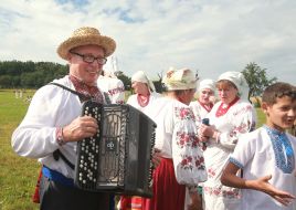 A man with an accordion in a national Ukrainian costume and a straw hat