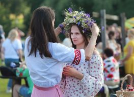A young woman tries on a wreath of wild flowers