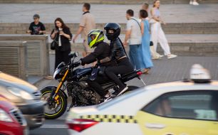 A young man and woman ride a sports motorcycle