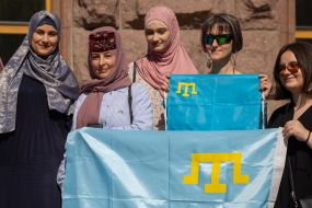Crimean Tatar women and other participants of the action hold Crimean Tatar flags