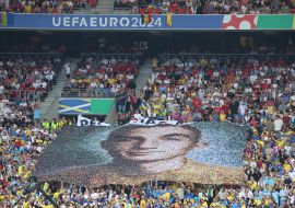 Fans hold a banner with the image of Nazariy "Grinka" Grintsevich