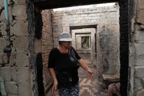 A local resident shows her dilapidated greenhouse