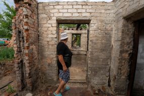 A local resident shows her dilapidated greenhouse