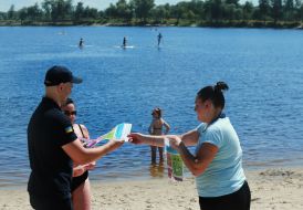 Спасатели раздают отдыхающим печатные материалы с правилами обращения на воде
