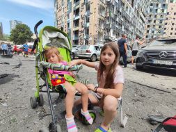 Children near the building of the Ohmatdyt Children's Hospital, which was hit by a rocket