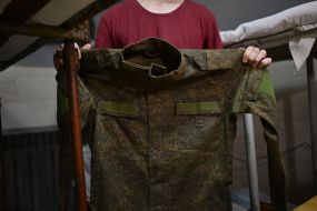 A Russian prisoner of war shows his uniform in a cell in one of the Ukrainian prisons