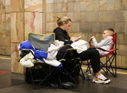 People hide from enemy rockets and mortars at one of the Kyiv metro stations
