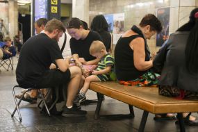 People hide from enemy rockets and mortars at one of the Kyiv metro stations
