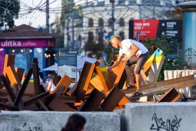 A man paints anti-tank hedgehogs in the colors of the Ukrainian flag on the street in Kyiv