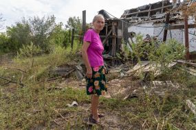 A local resident shows a dilapidated house
