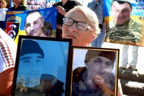 Женщина, держащая портреты военнослужащих