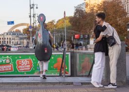 A girl with a musical instrument descends into an underground passage on Maidan Nezalezhnosti