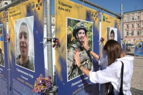 A woman near a portrait of a fallen serviceman
