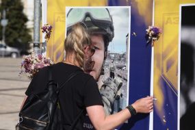 A woman near a portrait of a fallen serviceman