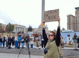 A woman holds a placard with the inscription "I stand for everyone" during a moment of silence on Independence Square in Kyiv