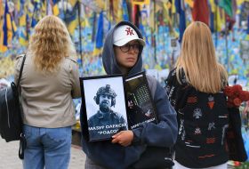 A woman with portraits of fallen soldiers on Independence Square in Kyiv