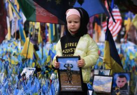 A girl with a portrait of a fallen soldier on Independence Square in Kyiv