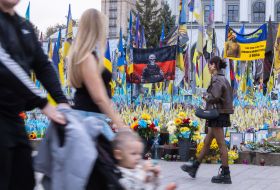 Баннер с изображением воина в маске карателя на территории импровизированного мемориала "Газон национальной памяти" в Киеве