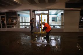 A utility worker cleans water in the lobby of the Dorogozhichi metro station in Kyiv