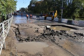Utility workers clean up the consequences of a water supply network break near the Dorogozhichi metro station in Kyiv
