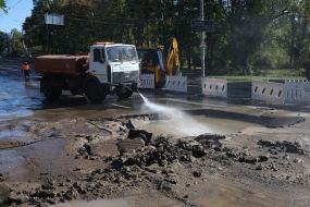 Utility workers clean up the consequences of a water supply network break near the Dorogozhichi metro station in Kyiv