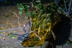 The body of the deceased covered with foil on a path in a park in Kharkiv
