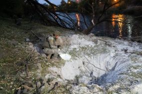 A sapper inspects a shell funnel in Kharkiv