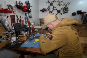 A fighter of the 57th brigade prepares new drones for flights before going on a mission in the Kharkiv region