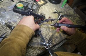A fighter of the 57th brigade prepares new drones for flights before going on a mission in the Kharkiv region