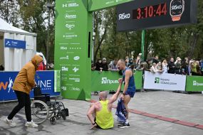 A woman rolls a wheelchair to the participants of the race