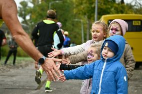 Дети приветствуют участника благотворительного забега