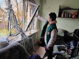 A boy near a window in a damaged apartment in Kyiv, broken as a result of falling debris from a downed drone