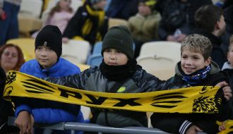 Хлопчики-вболівальники з банерами на трибуні