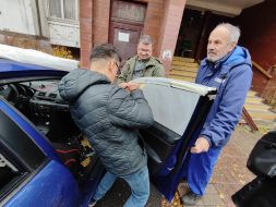 Men tape over a car window broken by a shrapnel from a suicide bomber in the Sviatoshynskyi district of Kyiv
