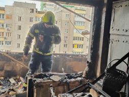 Спасатель в разрушенной после попадания обломков шахеда в жилой дом квартире в Святошинском районе в Киеве
