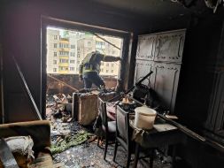 Спасатель в разрушенной после попадания обломков шахеда в жилой дом квартире в Святошинском районе в Киеве