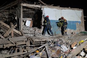 Rescuers at the ruins of a building housing a police station after a missile hit in Kharkiv