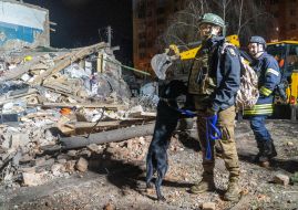Rescuers with a search dog at the ruins of a building housing a police station after a missile hit in Kharkiv