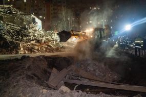 Rescuers at the ruins of a building housing a police station after a missile hit in Kharkiv
