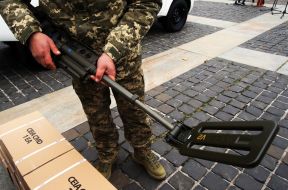 A soldier examines a metal detector
