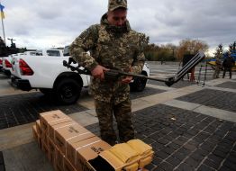 A soldier examines a metal detector