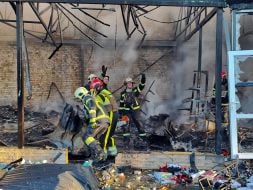 Rescuers extinguish a fire after the wreckage of a drone fell in the Solomianskyi district of Kyiv