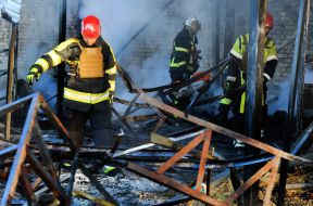 Rescuers extinguish a fire after the wreckage of a drone fell in the Solomianskyi district of Kyiv