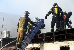 Rescuers extinguish a fire on a roof after the wreckage of a drone fell in the Solomianskyi district of Kyiv